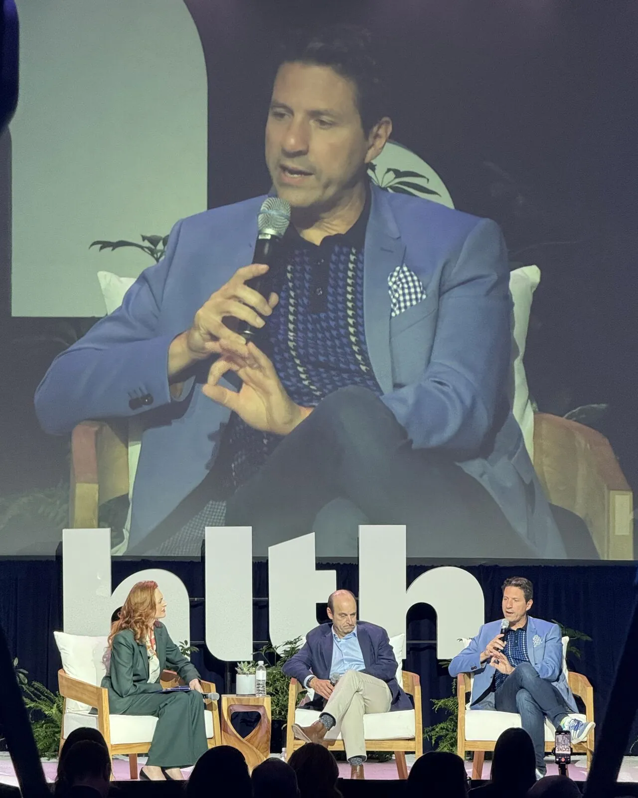 Emre Yücel with Greg Meyers of Bristol Myers Squibb, and the HLTH USA main stage in Las Vegas.